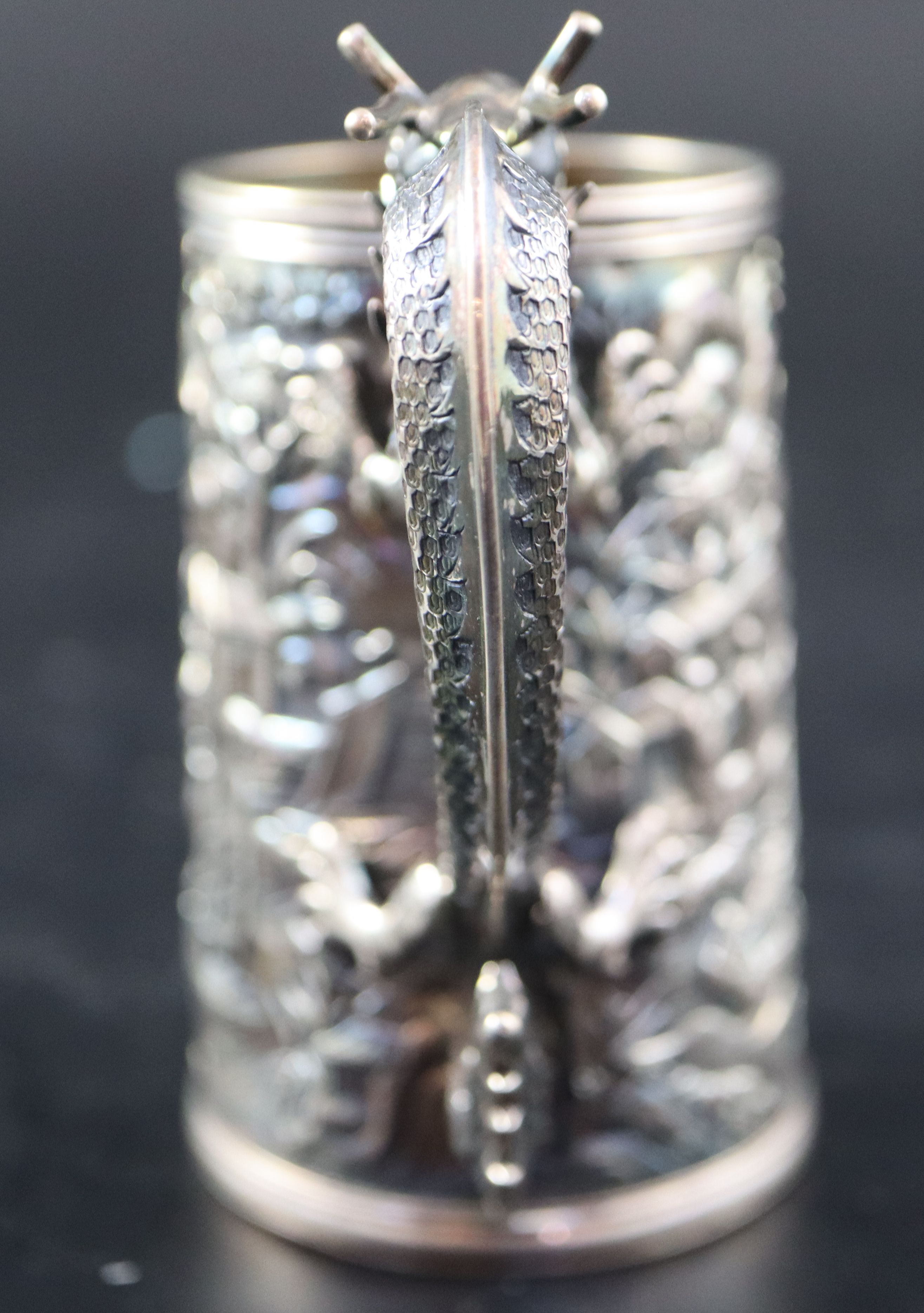 An early 20th century Chinese Export white metal christening mug by Wang Hing, with dragon handle